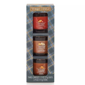 A set of three Yankee Candle jars stacked vertically in a packaging, each labeled as a different scent: Apple Pumpkin, Bahama Breeze, and Home Sweet Home.