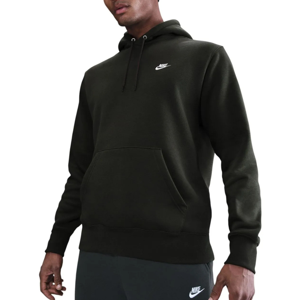 A person is wearing a dark green Nike hoodie with a small logo on the chest. The hoodie has a front pocket and drawstrings, paired with dark Nike sweatpants.