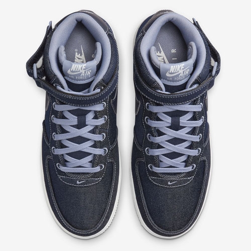 A pair of Nike Air Force 1 sneakers in a navy blue colorway with white detailing and laces.