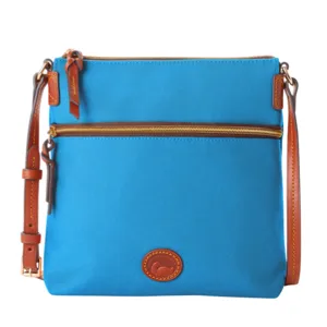 Blue crossbody bag with brown leather accents, adjustable strap, and two zippered compartments. Features a logo patch on the front.