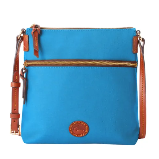 Blue crossbody bag with brown leather accents, adjustable strap, and two zippered compartments. Features a logo patch on the front.