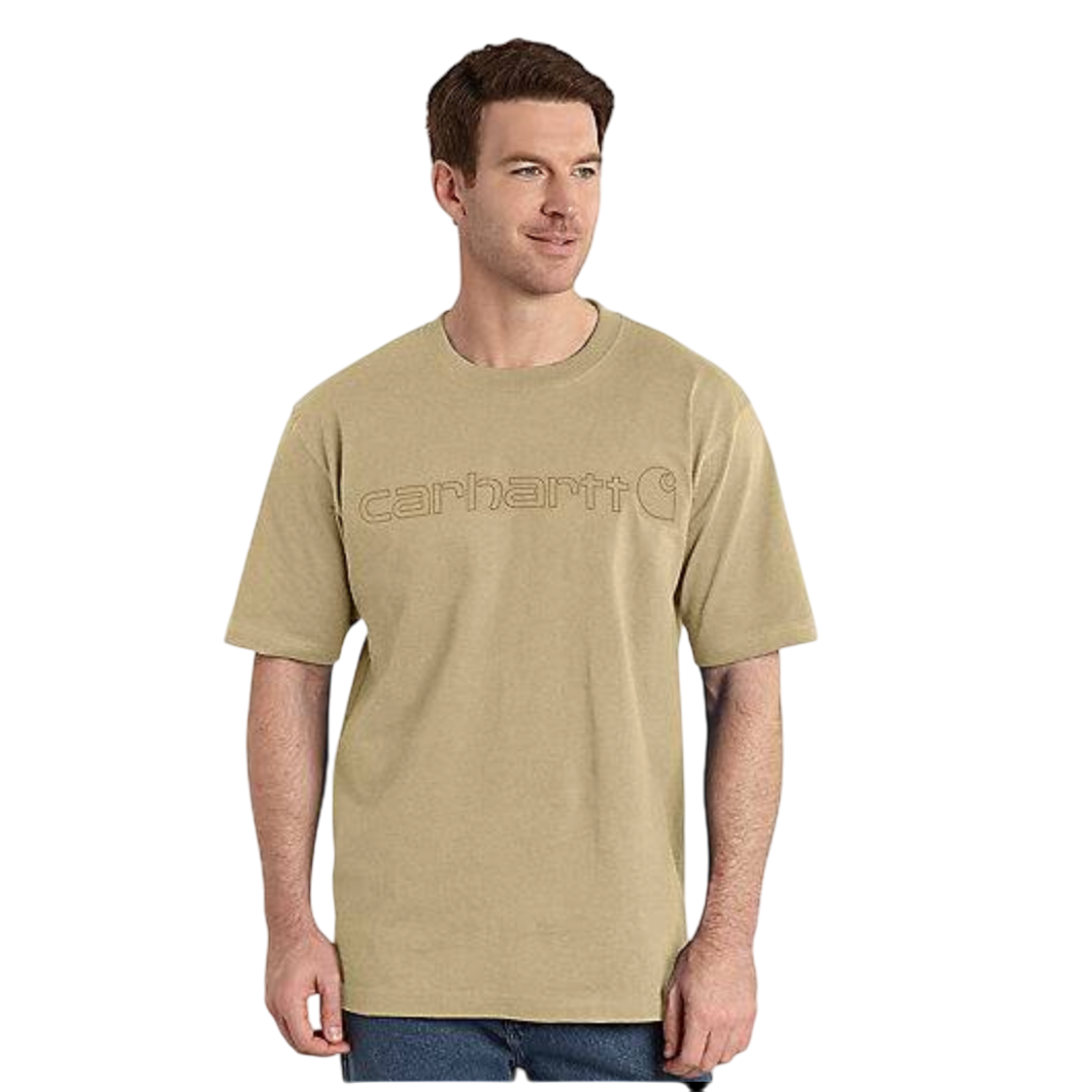 A man is wearing a beige Carhartt T-shirt with the brand name embroidered on the front, paired with blue jeans.