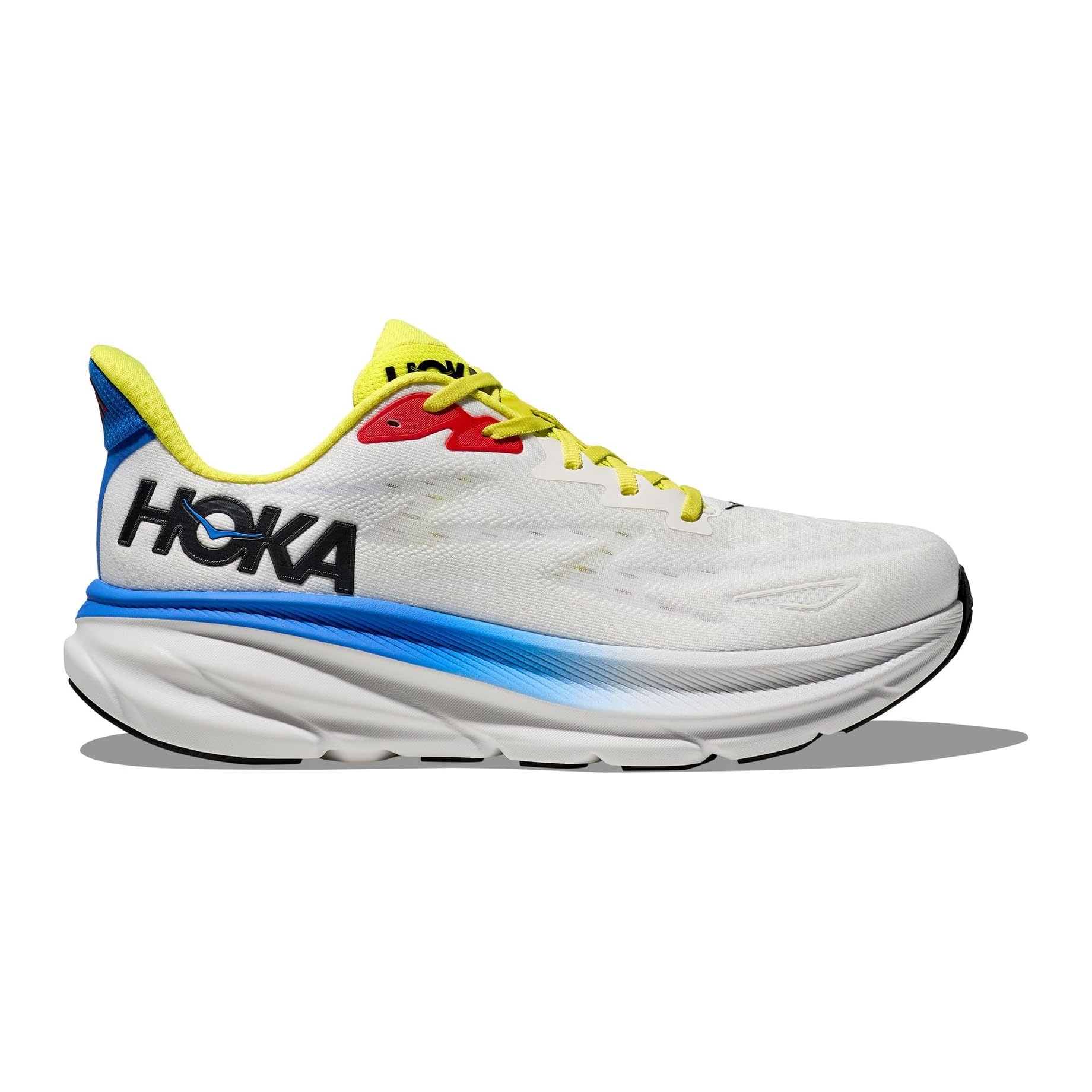 A white Hoka running shoe with bright yellow laces, a red accent near the laces, and a blue gradient on the midsole. The heel and interior lining are yellow and blue, featuring the Hoka logo in black.