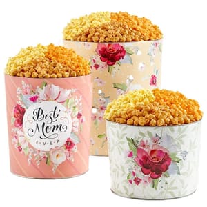 Three decorative tins filled with popcorn, featuring floral designs. One tin reads \“Best Mom Ever.\“