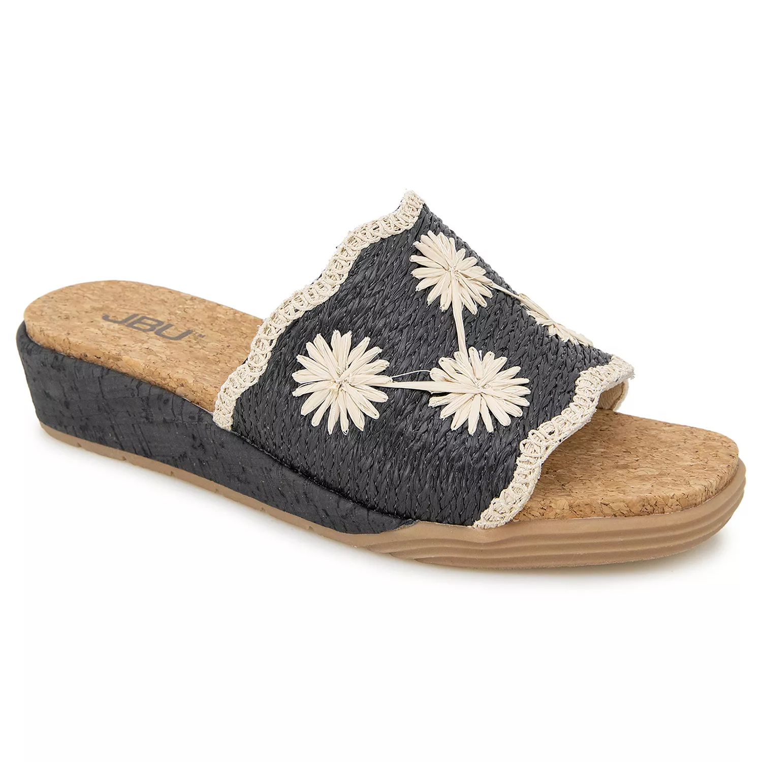 A women's slide sandal with a black woven upper adorned with white flower embroidery and a cork-like wedge sole. The brand \“JBU\“ is visible on the footbed.