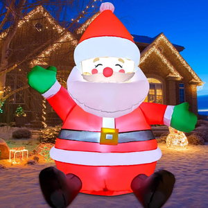 Inflatable Santa Claus decoration with green gloves and a black belt, set up in a snowy yard with holiday lights on a house in the background.