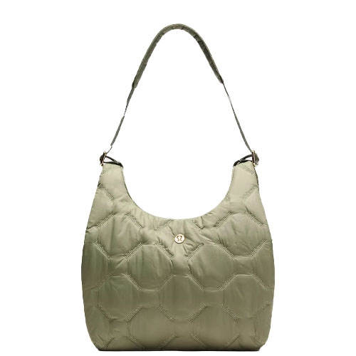A quilted shoulder bag in a light olive color with a single strap and a gold button detail in the center.