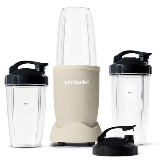 NutriBullet Pro 900W Blender includes a beige base with two tall clear cups featuring black flip-top lids, designed for blending smoothies and shakes efficiently.