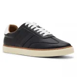 A low-top sneaker with textured black leather upper, white laces, a padded collar, and a cream rubber sole.