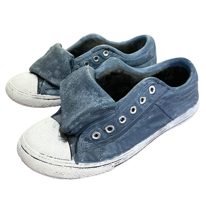 A pair of blue cement sneakers serving as planters, featuring white soles and toe caps, with eyelet details on the sides. The sneakers have an aged, worn look and are designed to hold small plants.