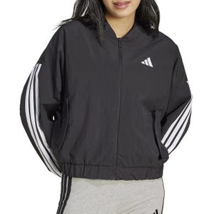 A black Adidas jacket featuring zip closure, white stripes on the sleeves, and the Adidas logo on the chest, paired with light grey pants with black stripes.