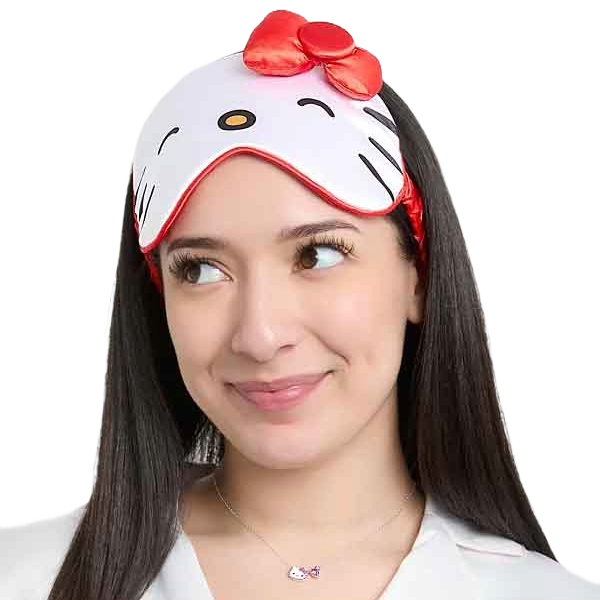 A person wearing a Hello Kitty-themed sleep mask featuring a red bow and whiskered design.
