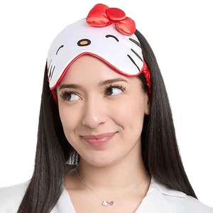 A person wearing a Hello Kitty-themed sleep mask featuring a red bow and whiskered design.