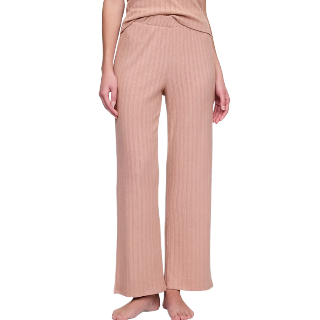 Ribbed wide-leg pants in a light brown or beige color are worn by a person with a matching top. The style is casual and comfortable, suitable for lounging.