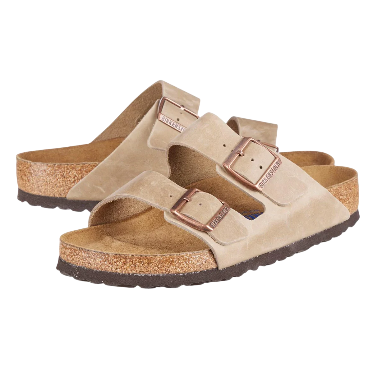 A pair of beige Birkenstock sandals with two adjustable straps and cork footbeds, featuring metal buckles for fastening.