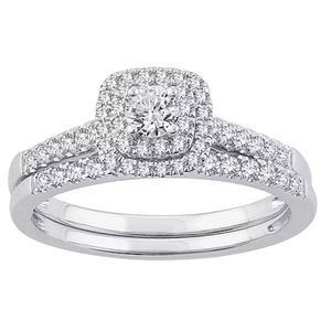 A silver ring set with a central round diamond surrounded by a halo of smaller diamonds, and additional diamonds lining the split shank.