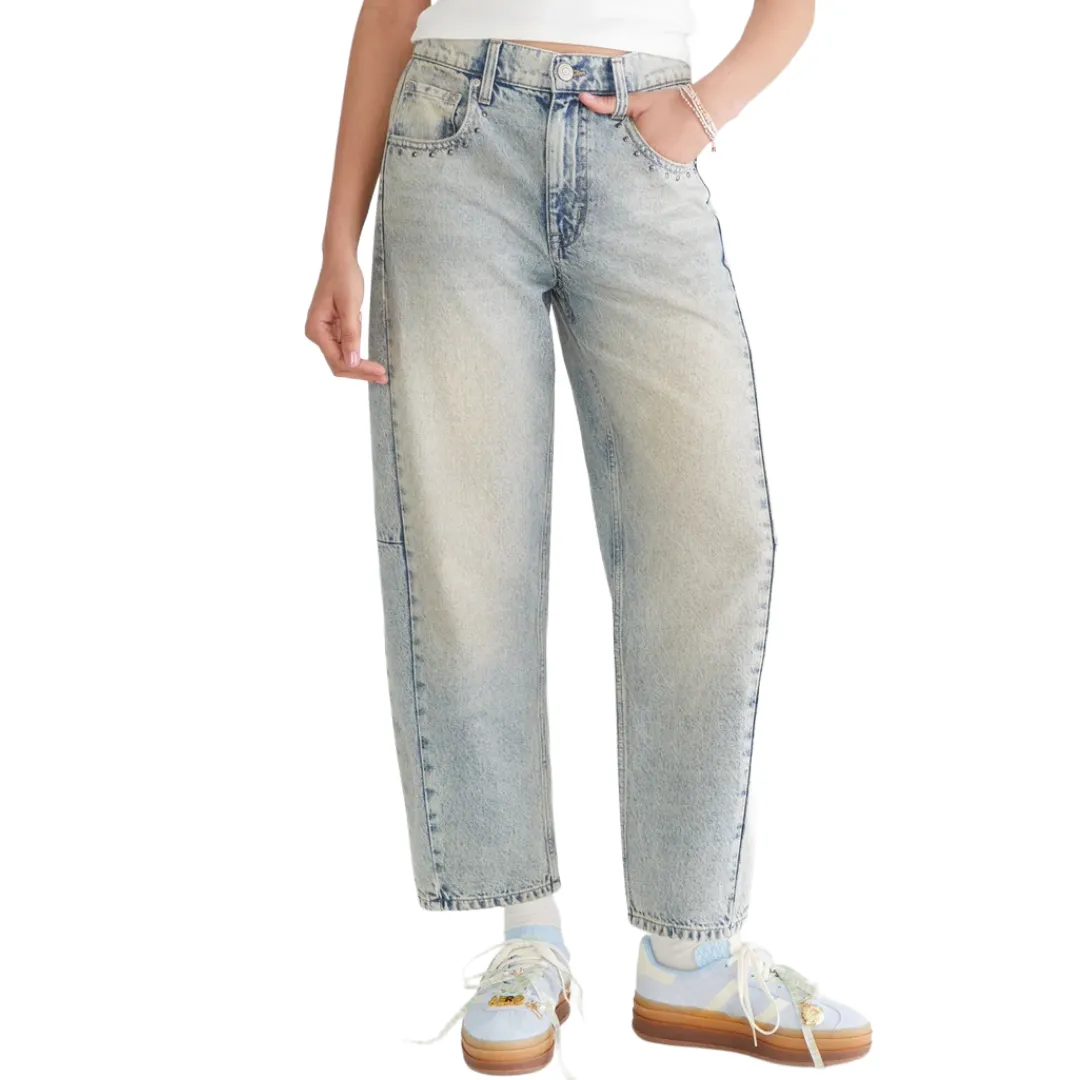 A person wearing light-wash, high-rise straight-leg jeans with a relaxed fit, paired with pastel sneakers featuring a thick sole.