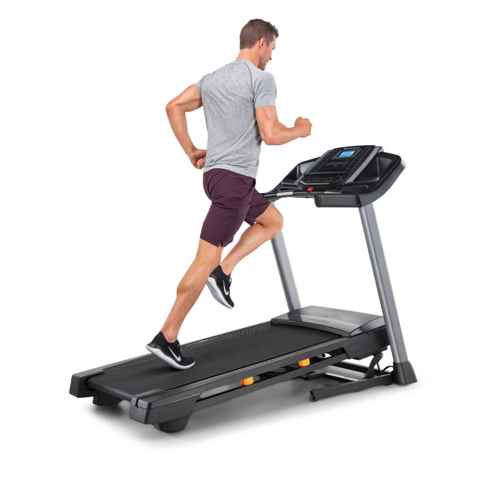 A man runs on a NordicTrack treadmill with a sleek design, featuring a digital console for tracking workouts. The treadmill has a sturdy frame and cushioned running surface for comfort.