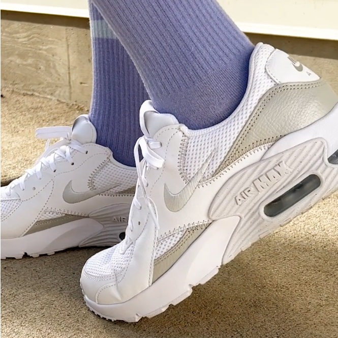 White Nike Air Max sneakers paired with light blue socks.