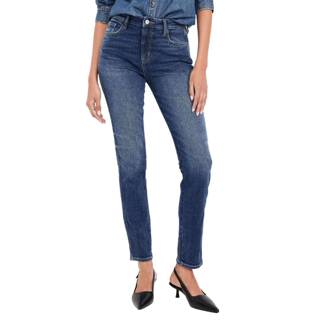 A person wearing medium-wash skinny jeans paired with a denim shirt and black heeled mules.