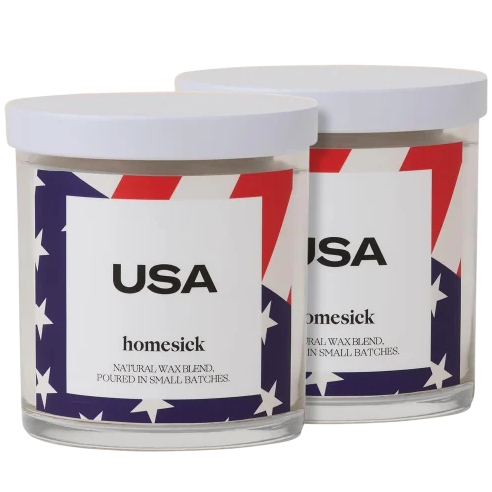 Two Homesick candles labeled \“USA\“ with a design featuring stars and stripes. They are described as a natural wax blend, poured in small batches.