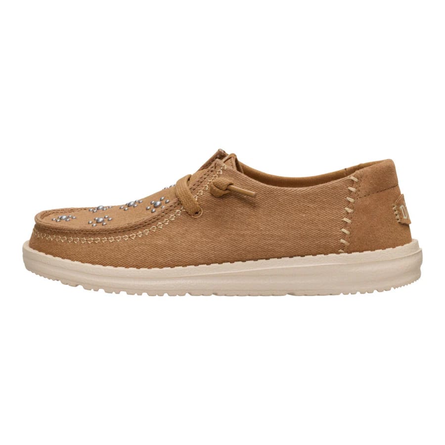 Tan casual shoe with a low profile and flat sole, featuring decorative stitching and metallic stud embellishments on the upper part.