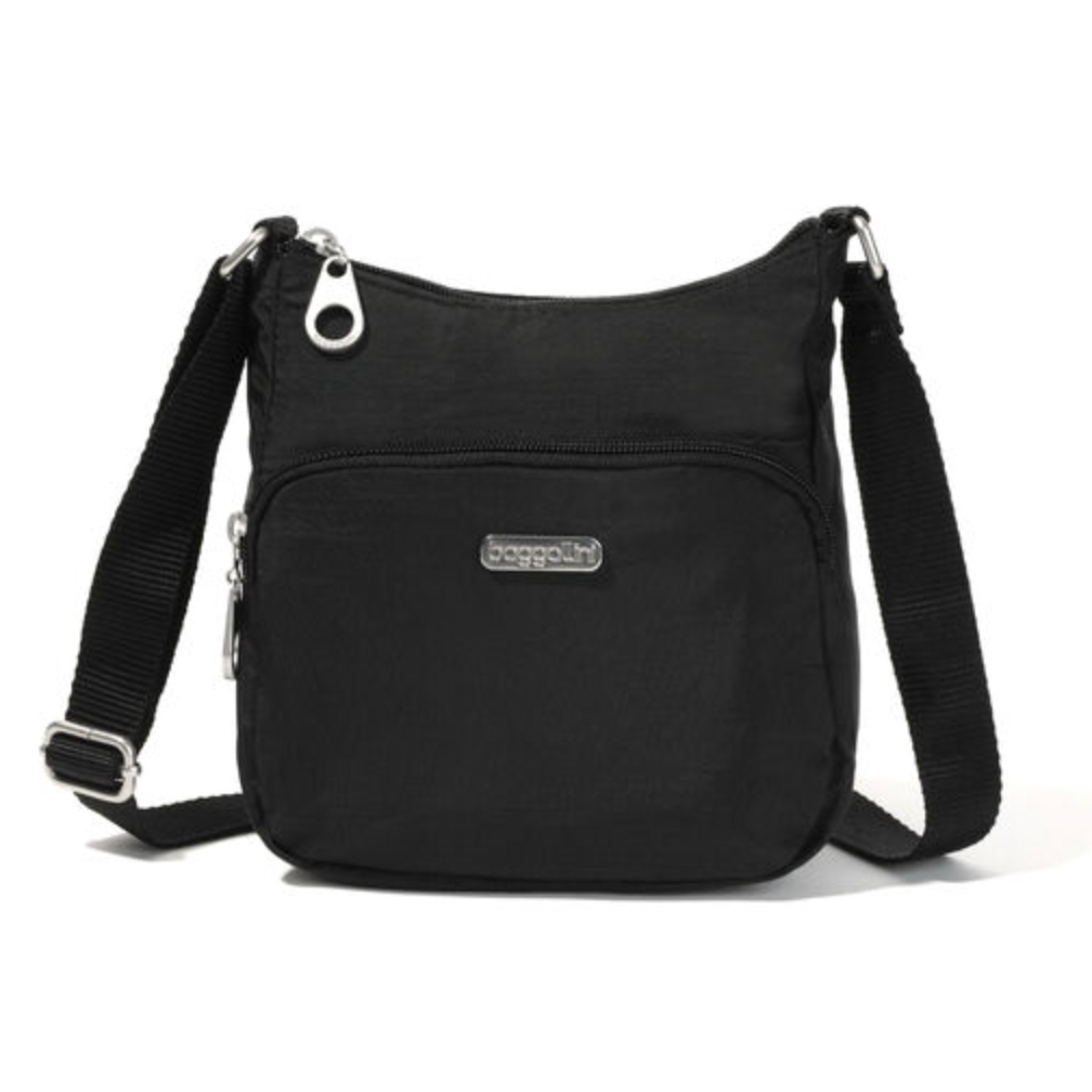A black crossbody Baggallini Joey Bagg with an adjustable strap, a front zipper pocket, and a branded logo plaque.