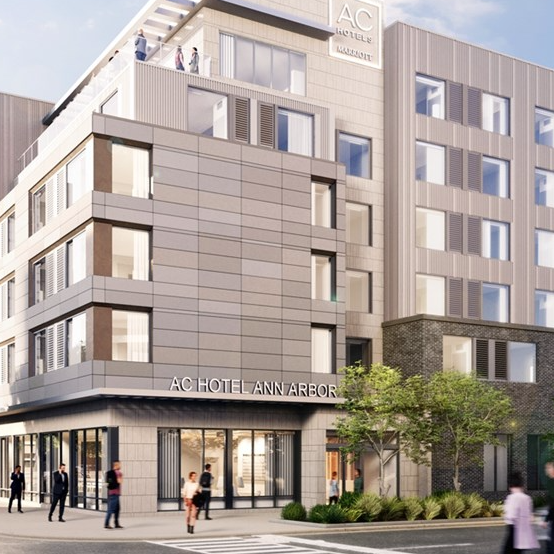 A modern building with \“AC Hotel Ann Arbor\“ signage, featuring multiple stories, large windows, and a rooftop area with people.
