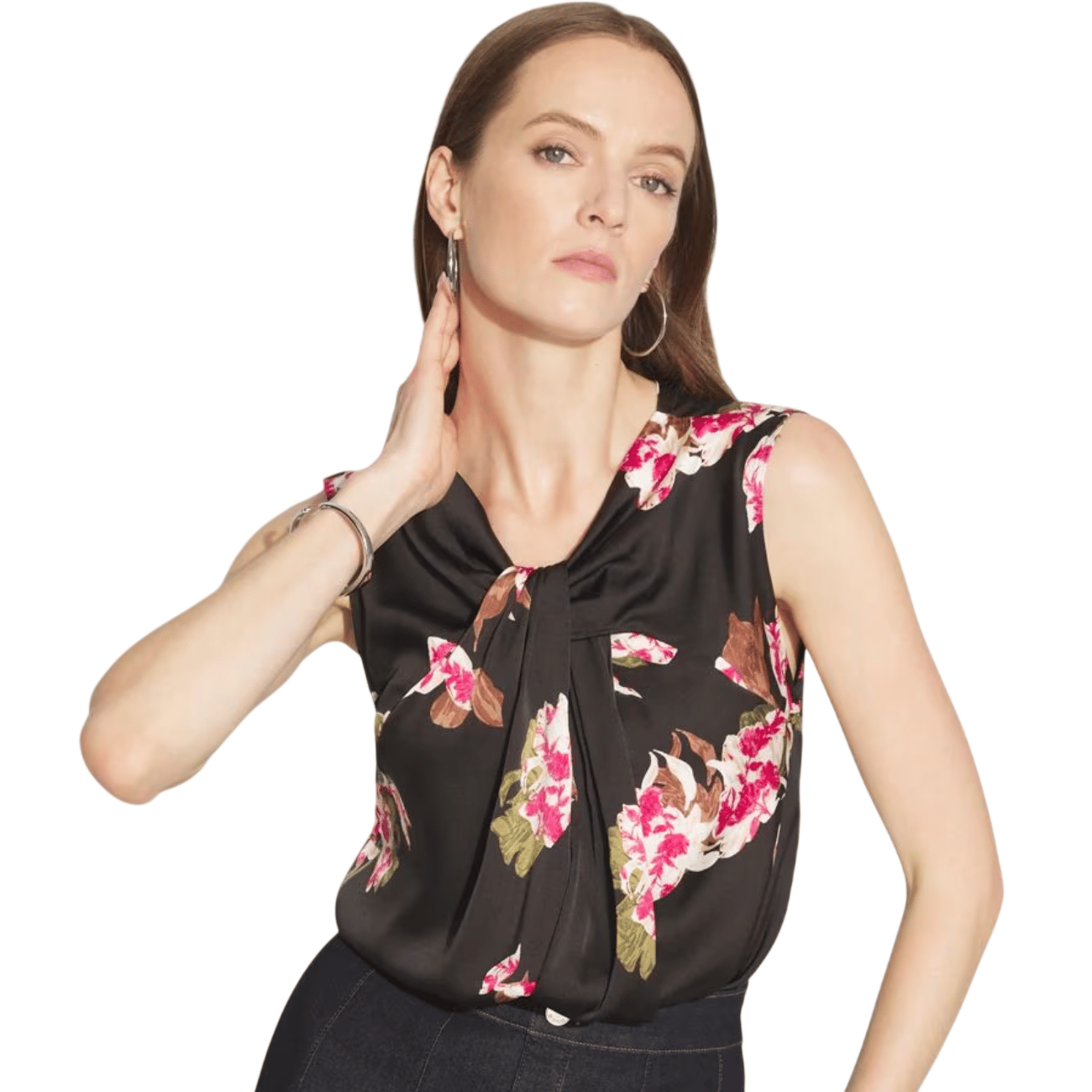 A woman is wearing a sleeveless black blouse with pink and white floral patterns, paired with dark pants.
