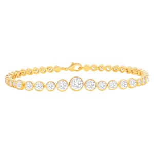 Gold tennis bracelet with round-cut stones set in individual bezel settings.