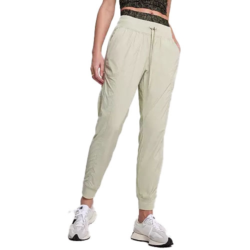 Light green joggers paired with a patterned crop top and white sneakers.