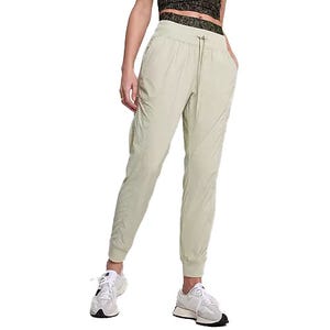 Light green joggers paired with a patterned crop top and white sneakers.