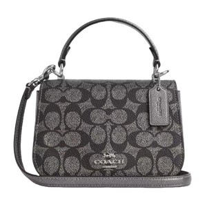 A Coach Outlet Top Handle Bag in black and gray signature jacquard pattern, featuring a detachable strap, a top handle, and a small tag with the brand name.