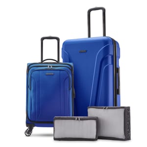 A four-piece luggage set featuring two blue suitcases, one with wheels and telescoping handle, and two grey packing cubes of different sizes.