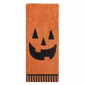 Orange hand towel with a black jack-o'-lantern face design and a striped border at the bottom.