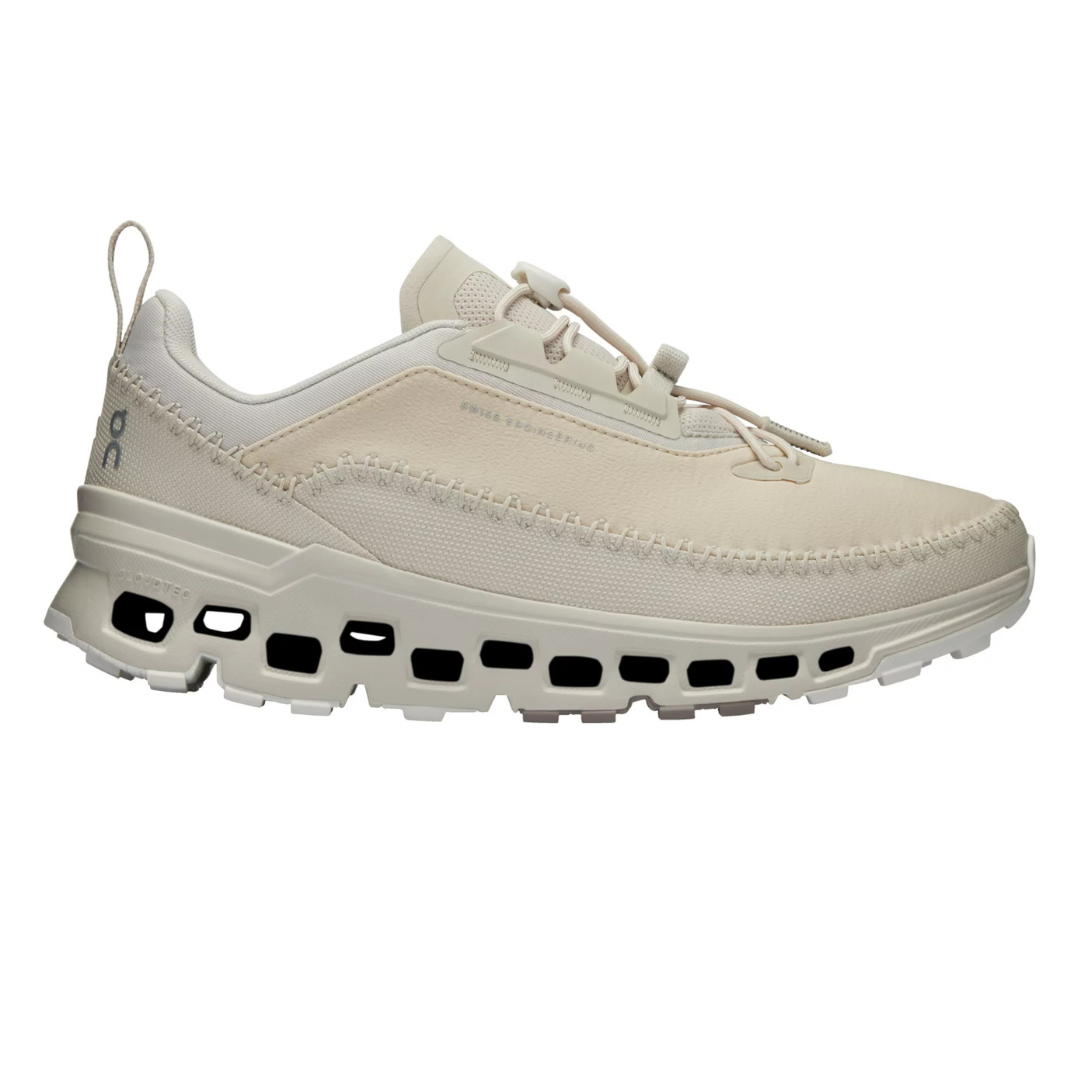 Beige sneaker with perforated sole design, features slip-on style with pull tab and stitched detailing.