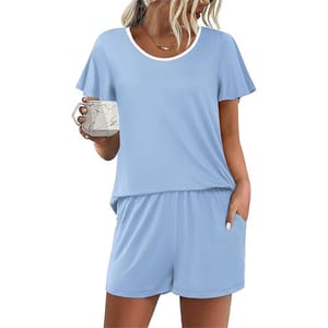 Light blue short-sleeve loungewear set featuring a round neckline and matching shorts with pockets. A woman is holding a mug.