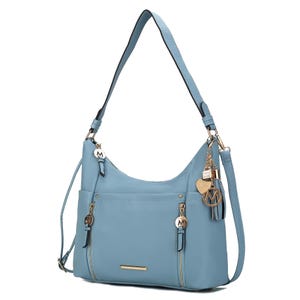 A light blue shoulder bag with gold-tone hardware, featuring a shoulder strap, front zippered pockets, and decorative charms.