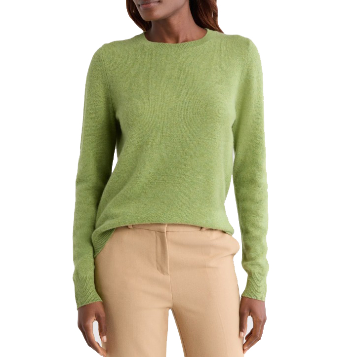 A woman is wearing a light green sweater paired with beige trousers.