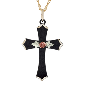 A black cross pendant features a rose and leaf embellishment, with gold accents on the edges, hanging from a gold chain.