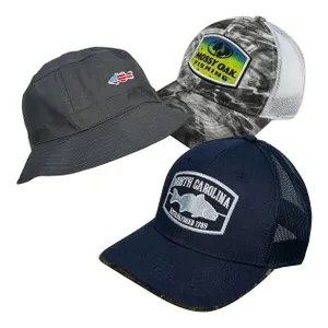 Three hats are shown: a gray bucket hat with a small flag patch, a camo mesh-back cap with a \“Mossy Oak Fishing\“ logo, and a navy mesh-back cap with a \“North Carolina Established 1789\“ patch.