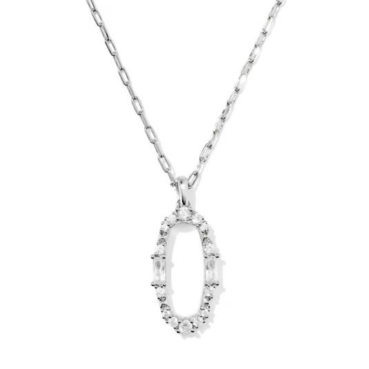 A silver necklace featuring an oval pendant encrusted with small, sparkling stones and two baguette gemstones on the sides.