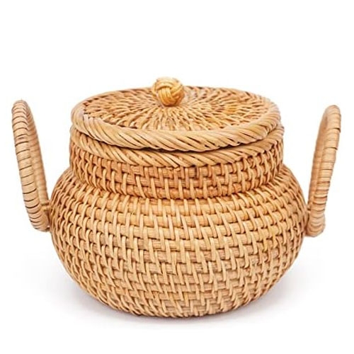 A woven rattan teapot-shaped basket with a lid and two handles, designed for decorative or storage purposes.
