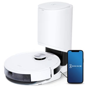 A white Ecovacs robotic vacuum with a self-emptying station, accompanied by a smartphone displaying the Ecovacs app.