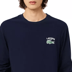 A navy blue long-sleeve t-shirt with a green Lacoste crocodile logo embroidered on the left chest area.
