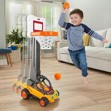 A Fisher-Price Basketball Hoop with an adjustable stand attached to a base, accompanied by a young child playing with an orange ball.