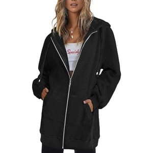 The women's long black hoodie features a front zipper, adjustable drawstrings, and large pockets. It is paired with a white crop top underneath that has the word \“Special\“ printed on it.