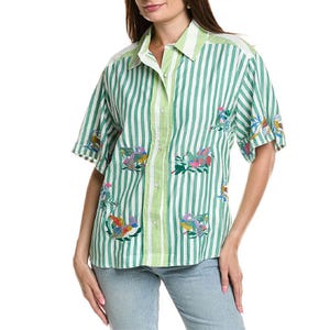 A green and white striped short-sleeve shirt with button closure, featuring colorful floral and bird embroidery, paired with light blue jeans.