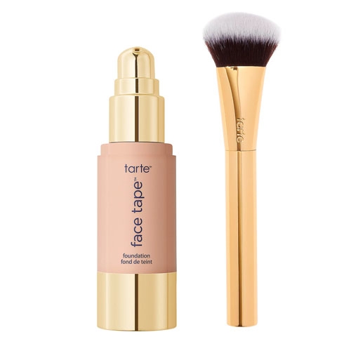 A bottle of Tarte Face Tape foundation and a flat-topped makeup brush.
