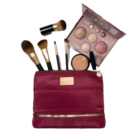 A burgundy makeup bag with a gold zipper displaying various brushes, a face palette with different powders, and a compact powder.
